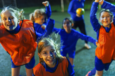 Portrait enthusiastic girls soccer team cheering - HOXF04179