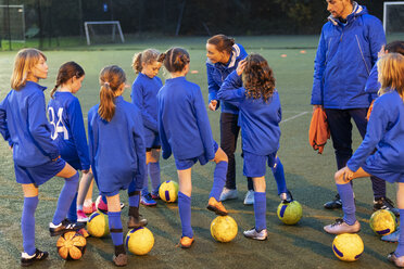 Girls soccer team listening to coaches on field - HOXF04185