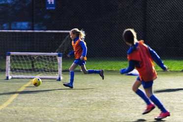 Mädchen laufen, spielen Fußball auf dem Feld - HOXF04187