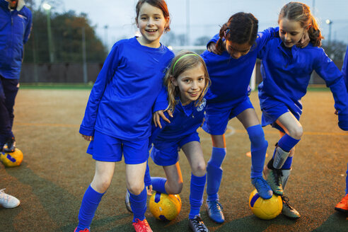 Portrait happy girls soccer team on field - HOXF04209