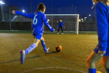 Mädchenfußballspieler, der den Ball in Richtung Tor schießt - HOXF04210