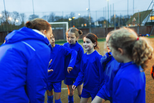 Mädchen-Fußballteam hört dem Trainer im Huddle zu - HOXF04211