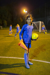 Porträt selbstbewusstes Mädchen Fußballspieler auf Feld bei Nacht - HOXF04212