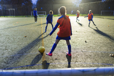 Girls soccer team practicing on field at night - HOXF04222