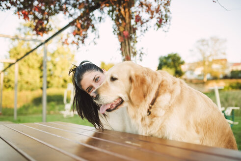 Porträt einer jungen Frau mit ihrem Golden Retriever Hund, die sich in einem Park ausruhen - RAEF02255