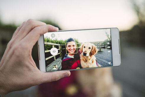 Handybild einer glücklichen jungen Frau mit ihrem Golden Retriever Hund im Freien - RAEF02266