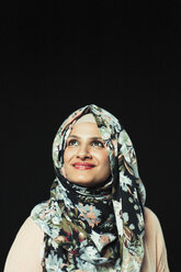Porträt einer selbstbewussten, ehrgeizigen Frau mit geblümtem Hijab, die nach oben schaut - CAIF22358