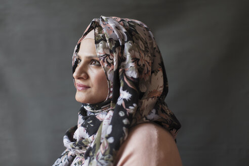 Gelassene, nachdenkliche Frau mit geblümtem Hijab, die wegschaut - CAIF22363