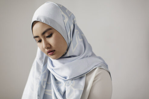 Gelassene junge Frau mit blauem Seiden-Hidschab - CAIF22376