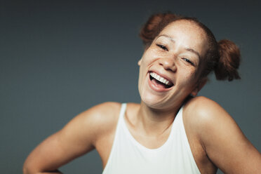 Portrait sorglose Frau mit Sommersprossen lachend - CAIF22377