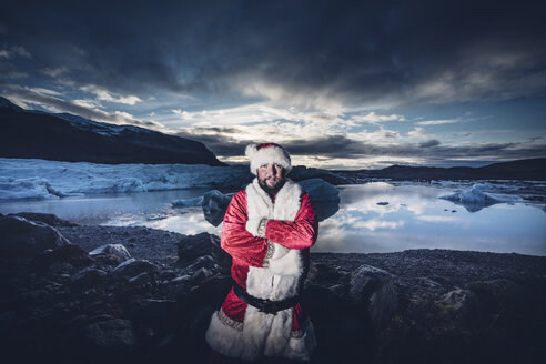 Island, Porträt eines als Weihnachtsmann verkleideten Mannes auf einem Gletscher - OCMF00169