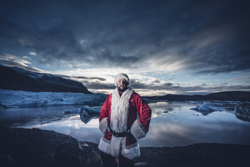 Island, Porträt eines als Weihnachtsmann verkleideten Mannes auf einem Gletscher - OCMF00170
