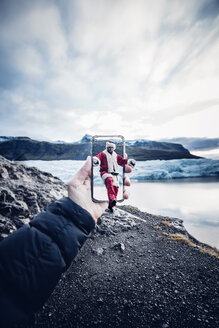 Island, ein als Weihnachtsmann verkleideter Mann, der aus einem Mobiltelefon kommt - OCMF00171