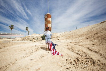 Mädchen mit amerikanischer Flagge in karger Landschaft - ERRF00168