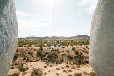 Car amidst desert against sky during sunny day - CAVF57492