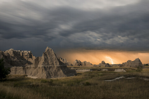 Majestätischer Blick auf Felsformationen im Badlands National Park bei Gewitter und Blitzschlag, lizenzfreies Stockfoto