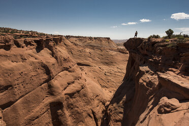 Ansicht aus mittlerer Entfernung von einem Mann, der auf einer Klippe im Grand Staircase-Escalante National Monument steht, gegen den Himmel - CAVF57507