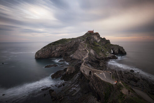 Blick auf San Juan de Gaztelugatxe inmitten des Meeres gegen den bewölkten Himmel bei Sonnenuntergang - CAVF57560