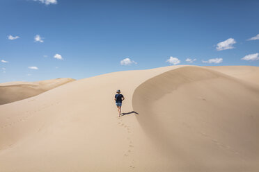 High angle view of woman walking on sand at Great Sand Dunes National Park during sunny day - CAVF57574