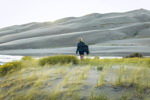 Rear view of woman amidst plants at Great Sand Dunes National Park - CAVF57578