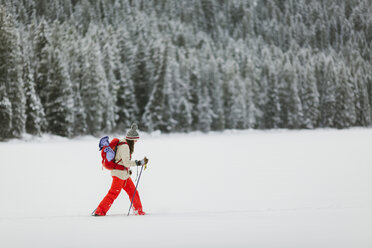 Seitenansicht einer Frau beim Wandern auf einem schneebedeckten Feld - CAVF57579