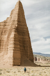 Rear view of hiker by rock formations at desert - CAVF57592