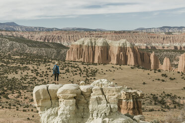 Full length of female hiker standing on rock formation at desert - CAVF57596