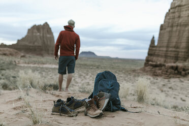 Wanderer in voller Länge, der die Aussicht mit Schuhen und Rucksack im Vordergrund in der Wüste betrachtet - CAVF57600