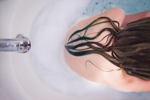 Hoher Blickwinkel eines Mädchens ohne Hemd, das in der Badewanne sitzt, lizenzfreies Stockfoto