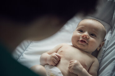 Ausgeschnittenes Bild einer Mutter, die ihren Sohn ohne Hemd zu Hause in der Krippe liegen sieht - CAVF57690