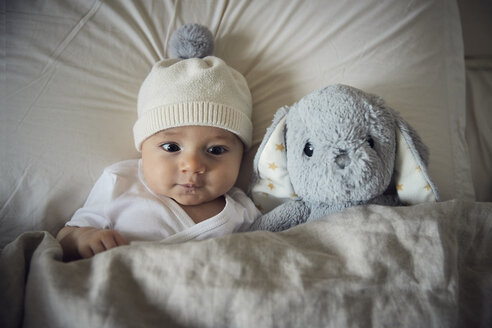 Hohe Winkel Ansicht von Baby-Junge mit Teddybär auf dem Bett zu Hause liegen - CAVF57692