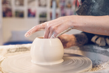 Mittelteil einer Frau, die in einer Werkstatt auf einer Töpferscheibe Keramik herstellt - CAVF57761