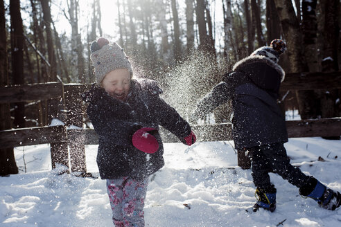 Geschwister spielen mit Schnee im Wald - CAVF57773