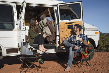 Freunde unterhalten sich beim Sitzen auf dem Campingplatz - CAVF57783