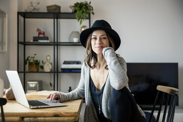 mature woman with hat, sitting at home, using laptop - MOEF01760