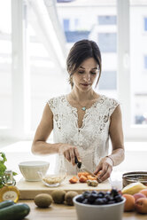 Woman preparing healthy food in her kitchen - MOEF01788