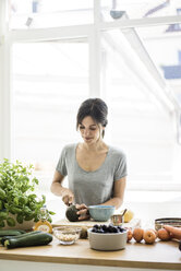 Woman preparing healthy food in her kitchen - MOEF01796