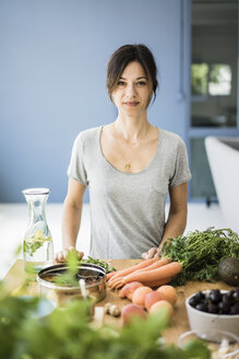 Woman preparing healthy food in her kitchen - MOEF01797