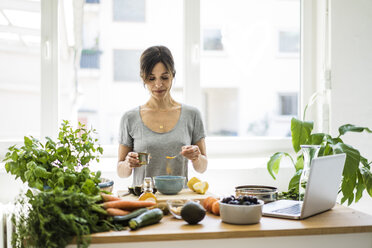 Woman preparing healthy food in her kitchen - MOEF01801