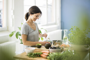 Woman preparing healthy food in her kitchen - MOEF01804