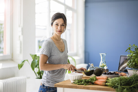 Eine Frau bereitet in ihrer Küche gesundes Essen zu, lizenzfreies Stockfoto