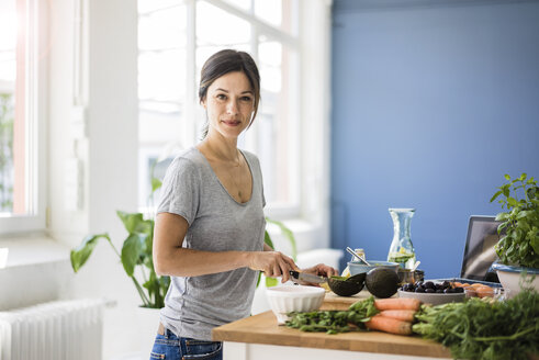 Woman preparing healthy food in her kitchen - MOEF01805