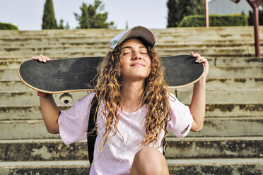 Mädchen mit Skateboard auf Stufen sitzend - ERRF00212