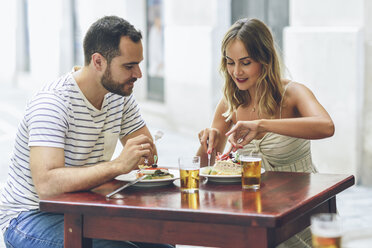 Pärchen beim Essen und Biertrinken in einem Restaurant auf der Straße - JSMF00596