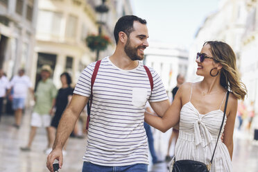 Spain, Andalusia, Malaga, happy tourist couple walking in the city - JSMF00599