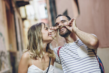 Spain, Andalusia, Malaga, funny man putting his girlfriend's hair as his mustache - JSMF00610