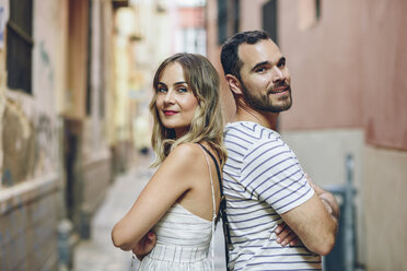 Spain, Andalusia, Malaga, portrait of a tourist couple standing back to back in the city - JSMF00611