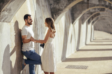 Spanien, Andalusien, Malaga, glückliches, zärtliches Touristenpaar unter einem Torbogen in der Stadt - JSMF00625