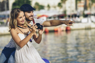 Spanien, Andalusien, Malaga, glückliches Touristenpaar beim Fotografieren am Hafen - JSMF00637