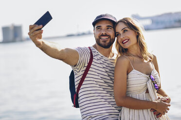 Spanien, Andalusien, Malaga, glückliches Touristenpaar macht Selfie mit Smartphone an der Küste - JSMF00638